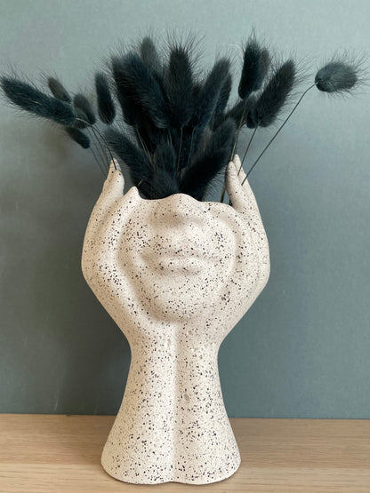 Woman face in hands vase