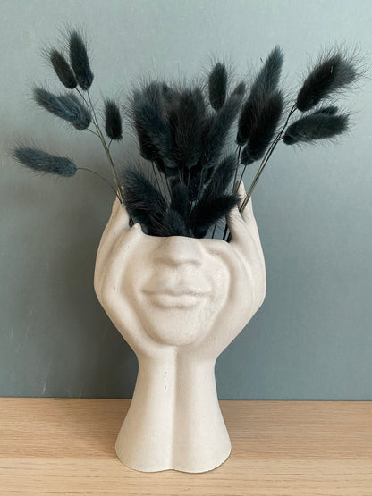 Woman face in hands vase